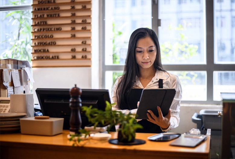 shop worker behind desk on tablet